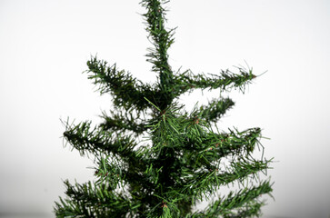 Obraz premium detalle de árbolito artificial de navidad verde sin adornos y fondo blanco