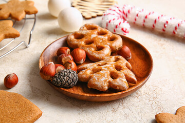 Plate with sweet Christmas gingerbread cookies on light background