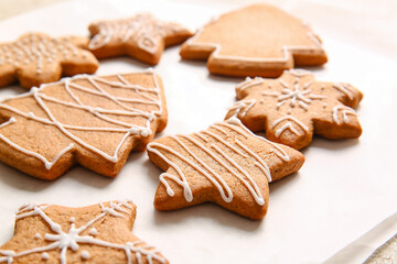 Parchment with sweet Christmas gingerbread cookies on light background, closeup