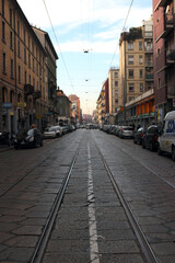 Old street in Milan with stone pavement and street car rail line. イタリア・ミラノの旧市街の路面電車線路の通る道と古風な町並み。