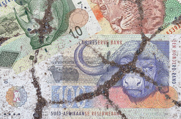 On the cracked asphalt there is an image of the South African Rand.