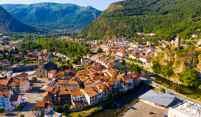 Fototapeta premium Panoramic aerial view of Tarascon-sur-Ariege commune surrounded by Pyrenees on sunny summer day, France