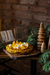 Orange pie marshmallows and sea buckthorn on a brick wall background