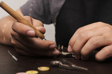 close-up of instrument repairman removing old pads from flute keys