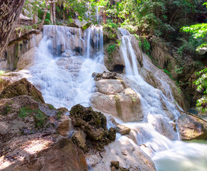 Fototapeta premium Erawan waterfalls in the national park mountains of Kanchanaburi BKK Bangkok Thailand lovely turquoise blue creamy waters lush green trees smooth rock formations