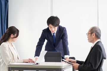 ミーティングで説明をするアジア人のビジネスマン