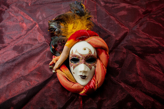 Carnival Venetian mask on red color background. Traditional festival Mardi Gras female disguise,