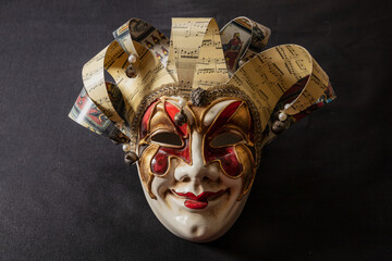 Carnival Venetian harlequin mask on black color background. Traditional festival disguise.