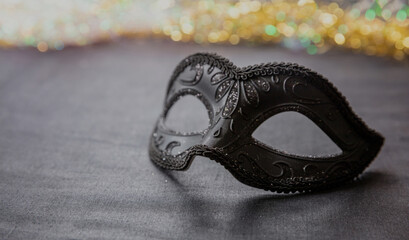 Carnival Venetian black mask on dark grey color background, female disguise, masquerade