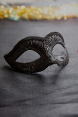 Carnival Venetian black mask on dark grey color background, female disguise, masquerade