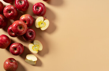 A lot of apples placed on a beige background, cut in half or quarter.