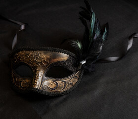 Carnival Venetian mask with feathers on black color background, female disguise, masquerade