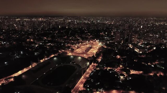 Night aerial landscape of sports scenery at Sao Paulo city Brazil. Cityscape near soccer stadium field. Pacaembu square avenue and sports stadium arena.