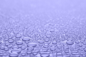 Water drops in Very peri color of the Year 2020, violet abstract background.