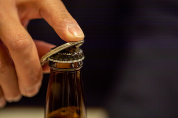 瓶ビールの栓をぬく手元　Stopper © 健二 中村