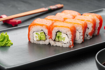 Fresh philadelphia sushi roll served on black plate