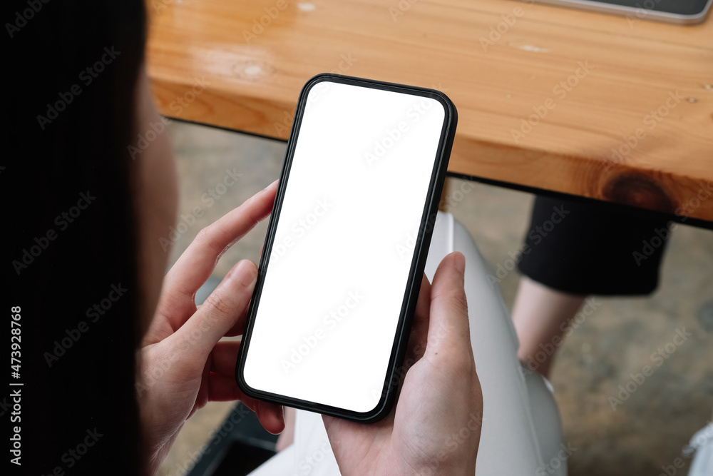 Wall mural mock up phone in woman hand showing white screen, female using mobile phone with blank screen for te