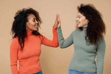 Two happy young curly black women friends 20s wearing casual shirts clothes meeting together...