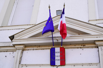 city hall facade france flag in town center on stone building with french text liberte egalite fraternite means freedom equality fraternity - obrazy, fototapety, plakaty