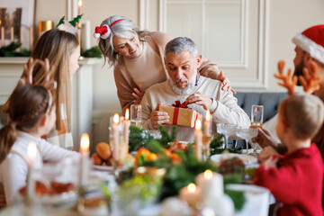Family make surprise for happy grandfather on Christmas , senior woman gives xmas present to husband