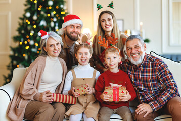 Happy multi generation family celebrating New Year or Christmas Eve together at home near xmas tree