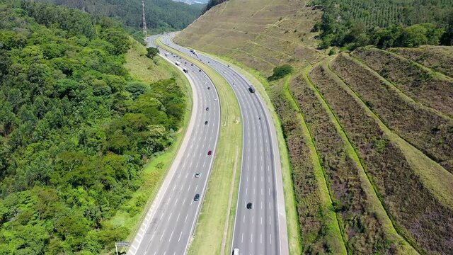 Aerial landscape of Bandeirantes highway road at countryside of Sao Paulo state Brazil. Landmark highway road between mountains. Rural landscape. Traffic at road. Brazilian freeway road.