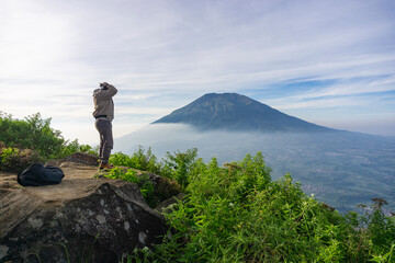 Landscape photo of mountain taken from highland with tree and bushes foreground . this is the view from top of Mount Telomoyo