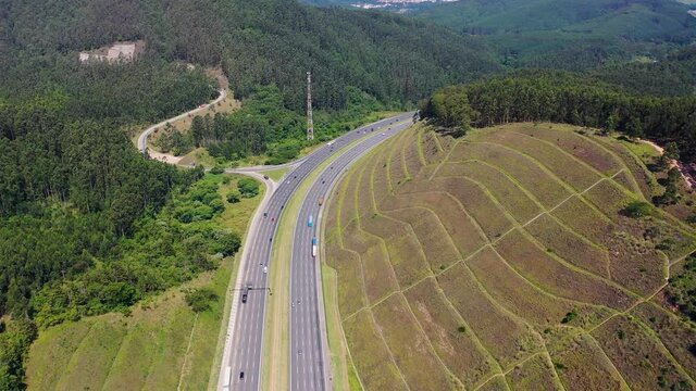 Aerial landscape of Bandeirantes highway road at countryside mountains. Landmark highway road between mountains. Rural landscape. Traffic at road. Scenic freeway road.