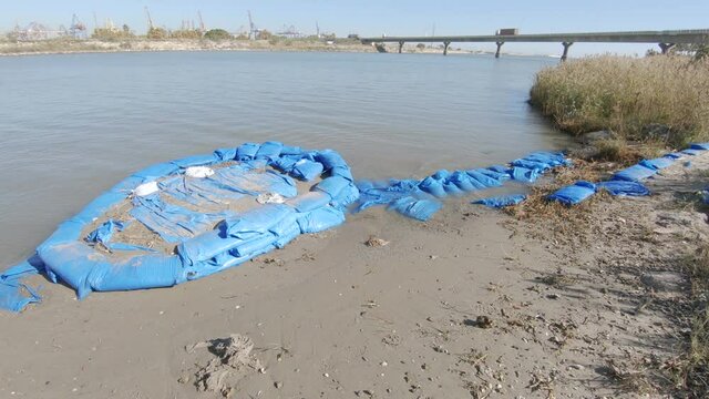 Blue plastic bags with sand to strengthen the river bank during floods