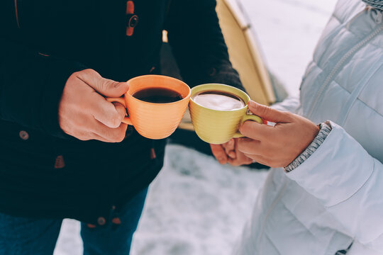 Two cups of tea in the hands of loving couple. winter theme