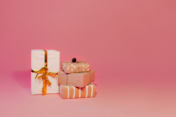 Kraft paper gifts on pink background. Many presents in kraft paper on pink background.