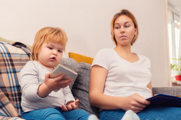 A little girl is playing with her phone, and her mother is not unwilling to look at it. The concept of children's addiction to online games