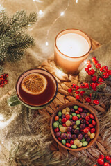 Obraz na płótnie Canvas evening tea party with Christmas lights hot tea and candy