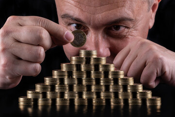 100 Kazakhstani tenge coins stacked in the form of a pyramid fnd mans face