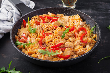 Heart-shaped pasta  in tomato sauce with chicken and sweet pepper with arugula. Background, texture