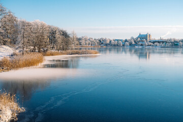 Fototapeta premium Wonderful winter view of Trakai, Vilnius, Lithuania, Eastern Europe, located between beautiful lakes and nature with frozen lake and snow, postcard