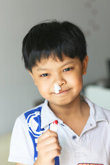 An Asian young boy using tissue to stop the nose bleeding. 