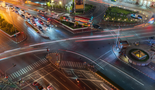 Aerial view of intersection or junction with cars traffic, Bangkok Downtown. Thailand. Financial district in smart urban city and technology. Skyscraper office buildings at night