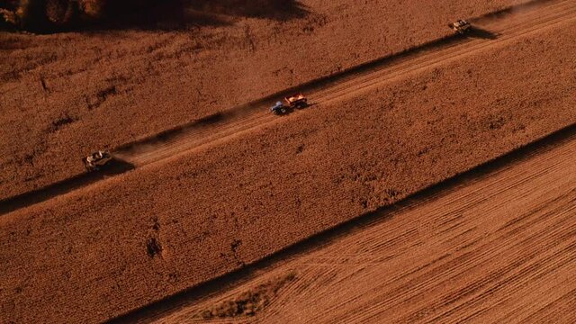 4K AERIAL FOOTAGE OF COMBINE OPERATION WITH SUPPORTING TRACTORS REAPING WEATH IN QUEBEC CANADA