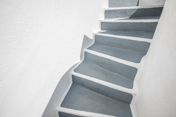 Empty stone stairway near white wall, abstract closeup in Santorini island, Greece. White architecture with gray steps. Minimal building detail