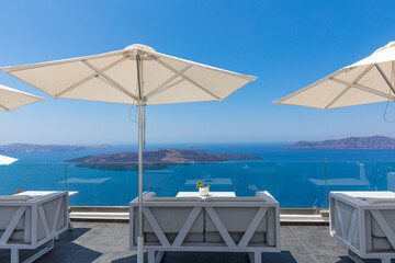 Fototapeta premium Beautiful sunny blue sky at Santorini island, Greece. Lounge chairs with umbrellas on the terrace with sea view. Travel destinations concept. Luxury summer destination, amazing landscape, Aegean sea