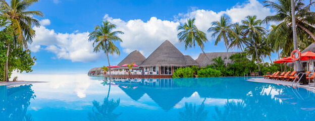 Outdoor tourism landscape. Luxurious beach resort with swimming pool and beach chairs or loungers...