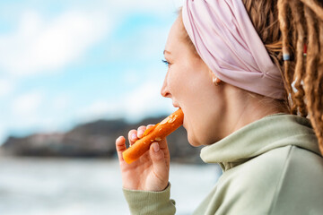Close up of a young woman with dreadlocks eating dried pastille. Concept of natural sugar free...