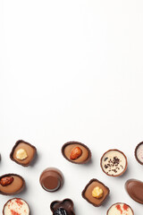 Flat lay composition with chocolate candies on white background