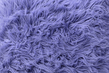 Purple soft fur for background or texture. Fluffy blue fur blanket. The color of 2022 very peri. Flat lay, top view, copy space