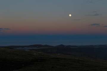 The moon in the setting cloudy winter sky
