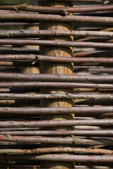 A close-up of a fence made out of branches of a Willow
