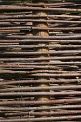 A close-up of a fence made out of branches of a Willow
