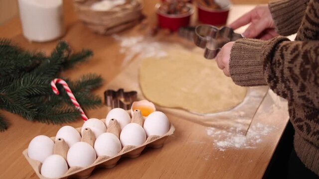 Woman making gingerbread at home. Female cutting cookies of gingerbread dough. Christmas and New Year traditions concept. Christmas bakery.