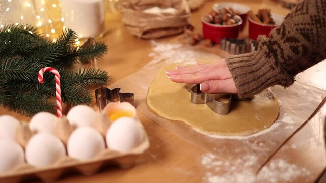 Woman making gingerbread at home. Female cutting cookies of gingerbread dough. Christmas and New Year traditions concept. Christmas bakery. Happy hollidays